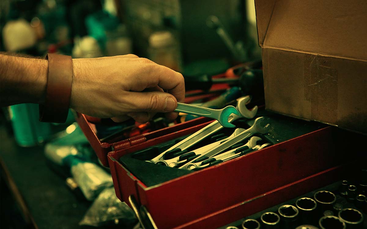 Man grabbing wrench from tool box